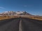 Stunning view of straight, empty road with diminishing perspective on SnÃ¦fellsnes, Iceland with rugged, snowy mountains.