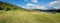 Stunning view to lake Geroldsee and karwendel mountains, green pasture with wooden huts and gentian flowers, landscape upper