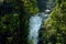 Stunning view of the waterfall through green forest