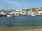 Stunning View of White Colored Houses and Blue Sea at the Old Port of Mykonos with a Flying Pigeon