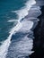 Stunning vista of a black sand beach adorned with rolling blue ocean waves