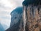 Stunning Waterfall Amidst Rugged Mountains in Murren, Switzerland.