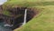 Stunning waterfall splashing from cliff aerial view. Mulafossur waterfall near Gasadalur Village at Faroe Islands