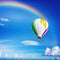 A stunning white hotr balloon with rainbow colors floating on a blue