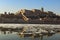 Stunning winter landscape of city Budapest. River Danube in little ice. In water reflected beautiful medieval Buda Castle.