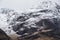 Stunning Winter landscape image of snowcapped Three Sisters mountain range in Glencoe Scottish Highands with dramatic sky