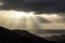 Stunning Winter sunrise landscape view from Loughrigg Fell across towards Windermere with stunning sun beams coming from the dark