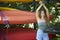 Stunning young brunette woman standing with bright canoes