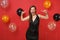 Stunning young girl in black dress celebrating blinking pointing index fingers on herself on bright red background air