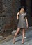 Stunning young woman in dress poses in alley