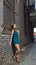 Stunning young woman in romper poses in alley