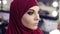 Stunningly beautiful girl with traditional arabic purple chiffon hijab covering her head has unrecognizable make up