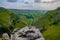 Stunningly beautiful vista of rolling hills and lush valleys, with a cloudy sky above.