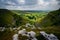 Stunningly beautiful vista of rolling hills and lush valleys, with a cloudy sky above.