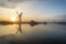 Stunnnig landscape of windmill and river at dawn on Summer morni