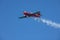 A stunt plane trailing smoke during a fly by at an airshow.