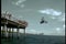 Stuntman driving motorcycle off pier into ocean