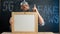 stupid conspiracy theory guy in a foil hat holds a blackboard with space for text. A bearded conspiracy theorist. Total