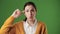 Stupid. Irritated woman on chroma key background green screen looking at camera and twirls her finger at her temple