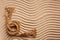 Sturdy marine rope on wavy texture sand. A place for text or for an advertising product. Top view