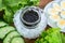 Sturgeon black caviar in small glass jar, few boiled quail eggs, some slices of cucunmber and fresh green lettuce on a brown