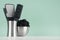 Style black accessories for skin cleansing - bath sponge, pumice, comb, toothbrush in silver bowls on green mint menthe wall.