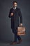 Style thats good to go. Studio shot of a stylishly dressed young man carrying a bag against a gray background.