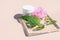 Styled beauty composition. Skin cream jar, peony flower, aloe vera leaf on glass podium. Organic cosmetics, spa concept.