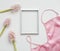 Styled feminine flat lay with blank photo frame, silk lingerie and pink flowers on white background. top view, copy