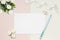 Styled stock photo. Feminine wedding desktop mockup. White roses, satin ribbon, beads on delicate beige background. Copy space. To