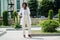 Stylish african american doctor with stethoscope and lab coat posed at backyard of hospital