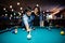 Stylish asian couple wear on jeans playing pool billiard on bar