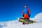 Stylish athlete snowboarder against the background of snow mountains