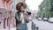 Stylish attractive curly African American black woman walking street and exploring sightseeing with camera. Young female