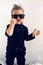 Stylish baby boy in black rocker clothes and sunglasses