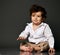 Stylish baby boy sitting on floor interested with his feet portrait