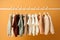 stylish baby clothes hanging on rack against color background