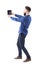 Stylish bearded young man taking selfie photo with tablet or large mobile phone. Side view