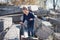 A stylish, beautiful boy is climbing large concrete slabs. The thrown concrete fragments