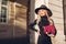 Stylish beautiful woman wearing dress hat and holding red purse outdoors. Female fashion. Spring accessories. Clothes