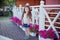 Stylish beautifull cute baby girl with brunette hair posing on wooden garden full of flowers wearing tiny jeans shirts and airy sk