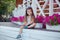 Stylish beautifull cute baby girl with brunette hair posing on wooden garden full of flowers wearing tiny jeans shirts and airy sk