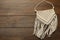 Stylish beige macrame on wooden table, top view. Space for text