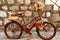 Stylish bike with pots for flowers against the background of brick blocks.