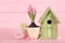 Stylish bird house and fresh hyacinths on pink wooden table