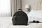 Stylish black backpack, tablet and sunglasses on bed in room