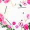 Stylish blogger workspace with clipboard, notebook, pink flowers and accessories on white background. Flat lay, top view.