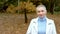 Stylish blond woman with very short hair walking in the autumn park.