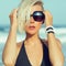 Stylish blonde walking on the beach in fashion accessories