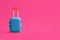 Stylish blue child suitcase on pink background